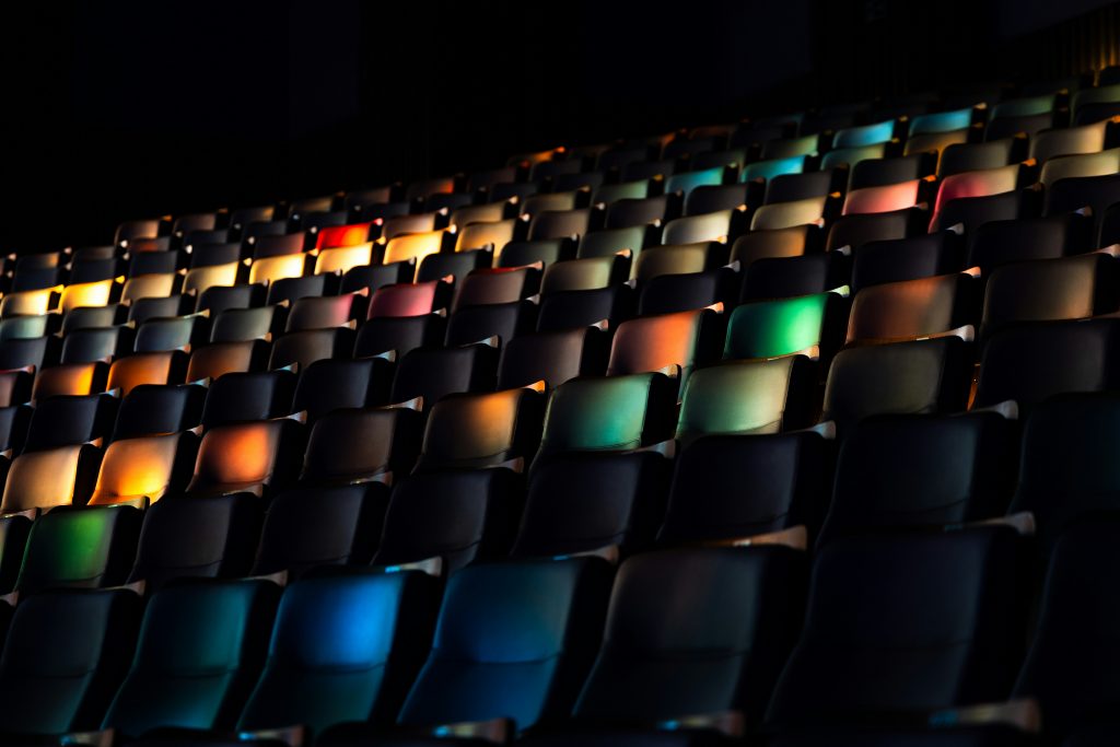 farbig ausgeleuchtete Theatersitze für Veranstaltungshinweis